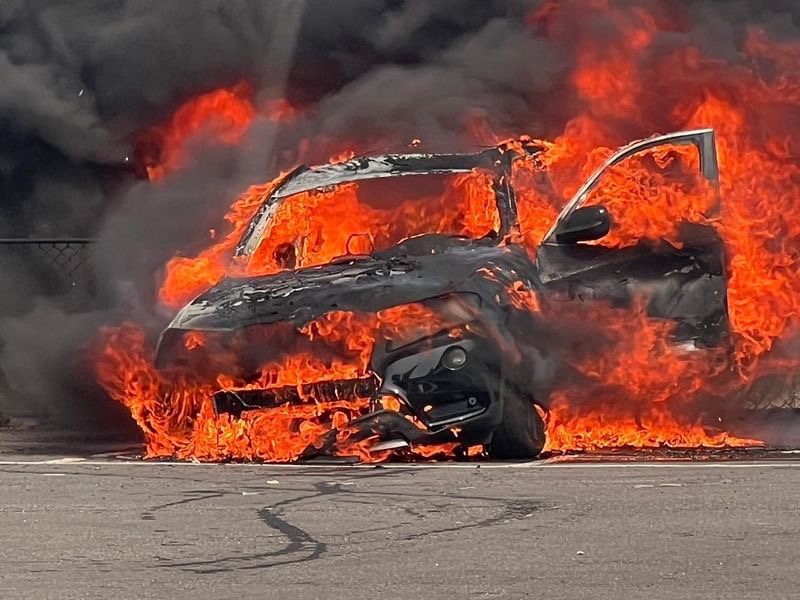 薛姓男子駕駛BMW休旅車停車時，發現底盤突然冒出濃煙，馬上離開車子，不久之後冒出熊熊大火。圖／民眾提供