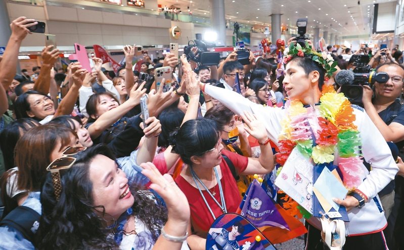 台灣拳後林鬱婷（右一）等中華隊選手今天返台，數百名支持者接機，大喊「台灣女兒林鬱婷」、「台灣之光」。她大方跟粉絲擊掌。 記者葉信菉／攝影