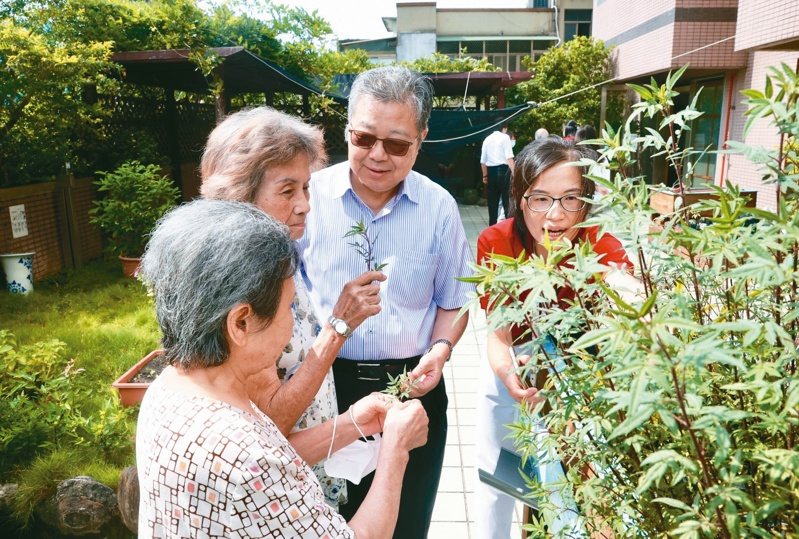 失智老人基金會執行長鄧世雄(左三)與機構的長者在頂樓花園分享園藝心得。記者林俊良／攝影