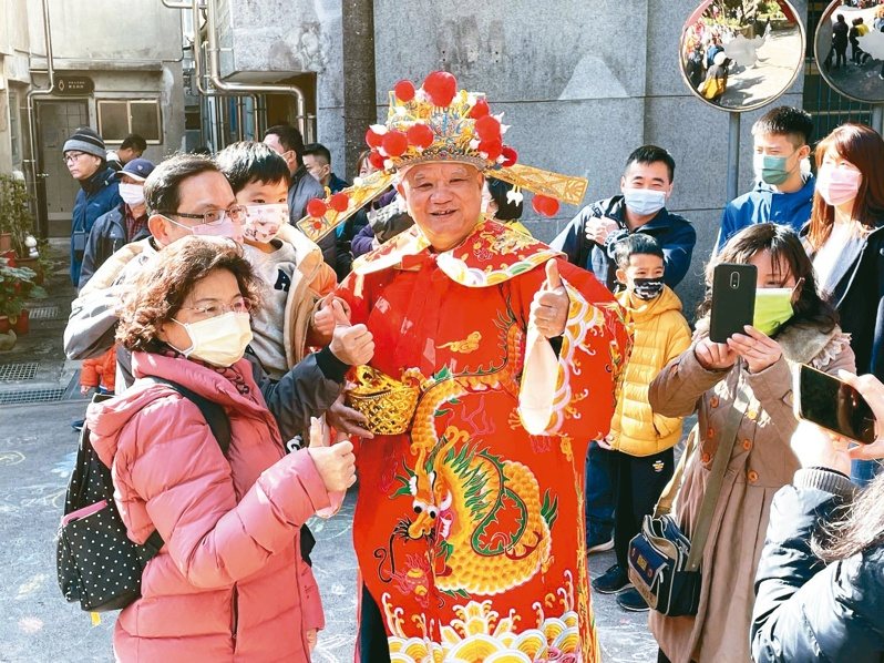 新北空軍三重一村頗受歡迎的傳統習俗「一村迎財神」，財神爺發送開運金幣巧克力。圖／新北市文化局提供