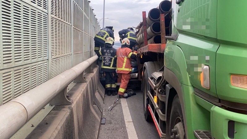 轎車被夾困在聯結車和護欄隔音牆之間，消防隊用破壞器材掀開車頂，才救出72歲沈姓駕駛。記者林昭彰／翻攝